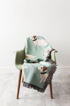 a chair with a blanket on top of it and a dog design on the back