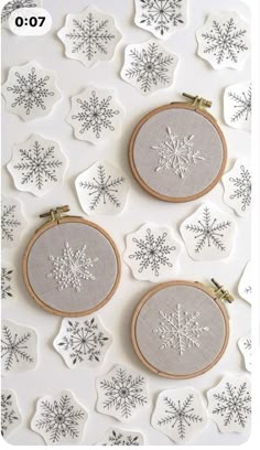 three cross stitch snowflakes are hanging on the wall