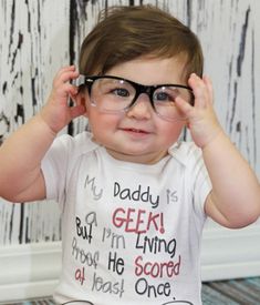 a baby wearing glasses with the caption daddy's a gamer