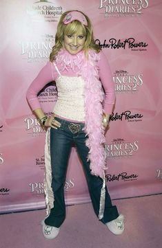 a woman in pink and white outfit posing for the camera with her hands on her hips