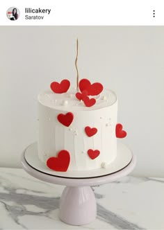 a white cake with red hearts on it