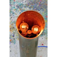 three light bulbs sitting inside of a metal cup