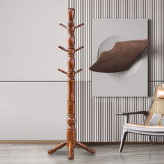 a tall wooden coat rack next to a chair