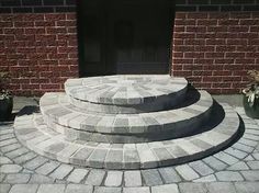 the steps are made of stone and have potted plants on each side in front of them