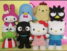 a group of hello kitty stuffed animals standing next to each other