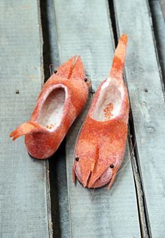 two orange slippers sitting on top of a wooden floor next to each other with holes in them