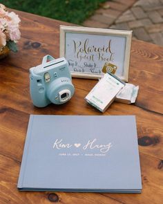 a table with a camera, notepad and other items sitting on top of it