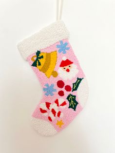 a pink christmas stocking hanging on a white wall