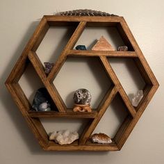 a wooden hexagonal shelf with various rocks and shells on the shelves in front of it