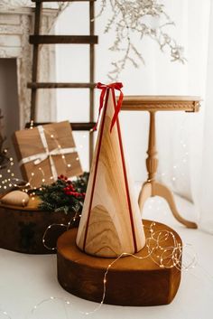 a wooden christmas tree with a red ribbon on it