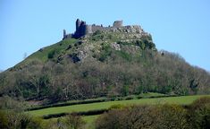 an old castle sits on top of a hill