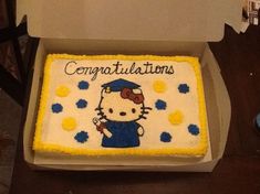 a hello kitty cake in a box with congratulations written on it