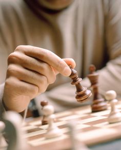 a man playing chess with his hand on the board