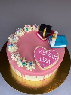 a cake decorated with pink icing and white flowers on a gold plated platter