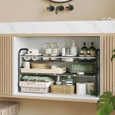 a bathroom with a sink, mirror and shelves filled with toiletries next to a wall mounted clock