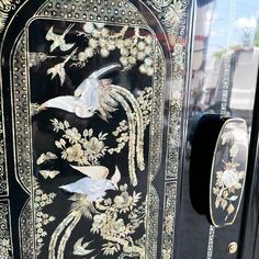 an intricately painted cabinet door with birds and flowers on the front, along with other decorative elements