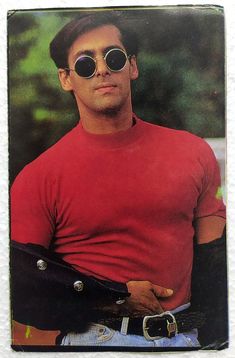 a man wearing sunglasses and holding a belt