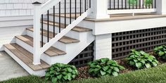 a white house with wooden steps and green plants