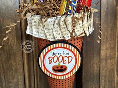 a halloween decoration with candy and candies in a tall cup that says booed