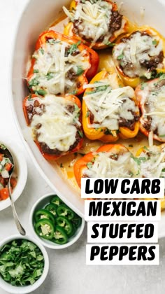 stuffed bell peppers with cheese and sauce in a white casserole dish next to small bowls of green vegetables