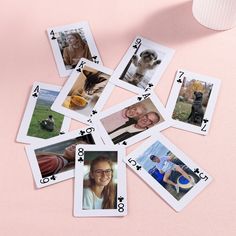 playing cards with pictures of dogs and cats on them are laid out next to a cup