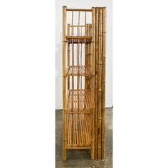 a tall bamboo shelf with four shelves on each side and one section open to show the inside