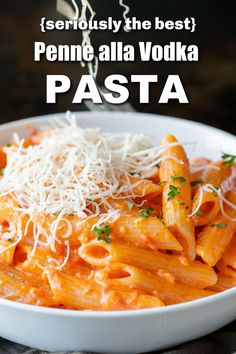 pasta with parmesan cheese in a white bowl on top of a black table