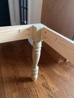 a wooden bench sitting on top of a hard wood floor next to a door way