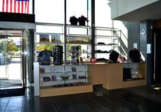 the inside of a clothing store with two people standing at the counter and looking out the window