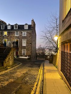 an empty street in front of some old buildings at night with no one on it