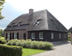 an old black house with a thatched roof