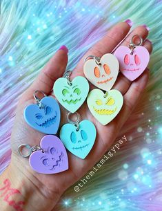 six heart shaped keychains are shown in the palm of someone's hand