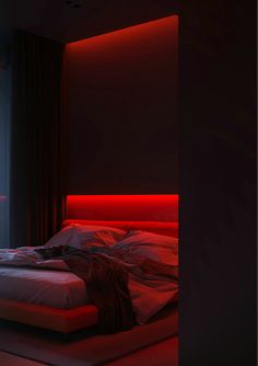 a bed with red sheets and pillows in a dark room