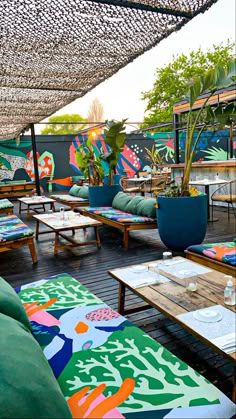 an outdoor seating area with colorful cushions and tables