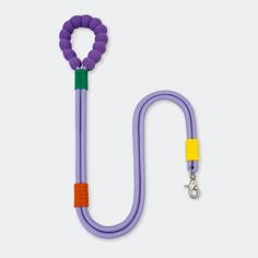 a purple leash with an orange and green hook on it, attached to a white wall