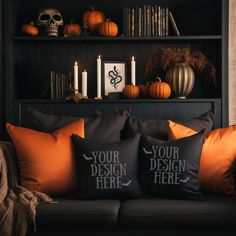 two black and orange pillows sitting on top of a couch in front of a bookshelf