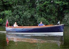 two people are riding in a blue boat on the water