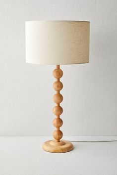 a wooden table lamp with a white shade