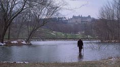 a man walking in the water near a castle