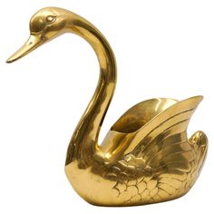 a gold swan figurine on a white background