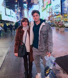 a man standing next to a woman on a city street