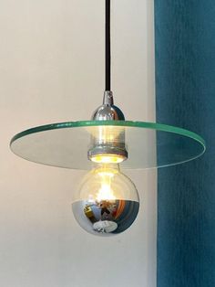 a light bulb hanging from the ceiling with a glass bowl on it's side