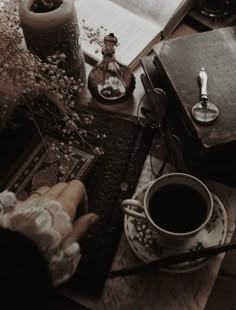 a person sitting at a table with an open book and coffee cup in front of them