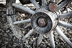 an old wooden wagon wheel on the ground