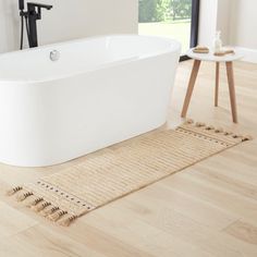 a white bath tub sitting on top of a wooden floor