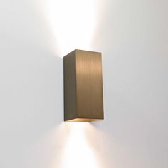 a wall mounted light on the side of a white wall