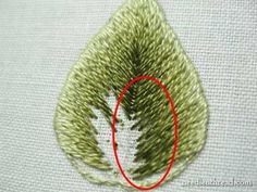 an embroidered leaf with a red circle in the center