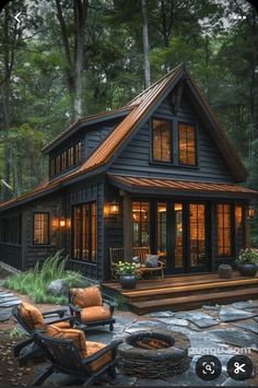 a small cabin in the woods with chairs and fire pit