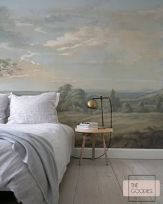 a bedroom with a large painting on the wall next to a bed and night stand