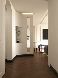 an empty room with white walls and wood floors is pictured in this image, there is a curved mirror on the wall